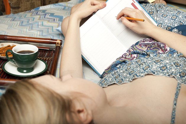 girl with cup of coffee writing something