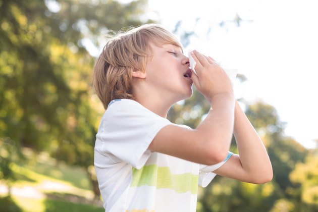 Little boy blowing his nose