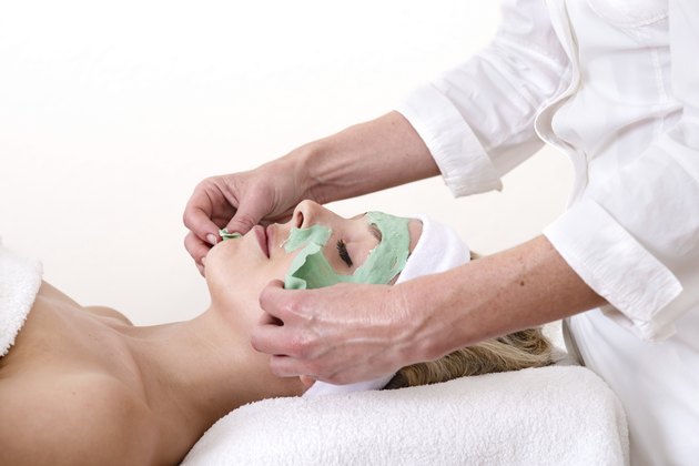 Beautician peeling off a green thalasso beauty facial mask.
