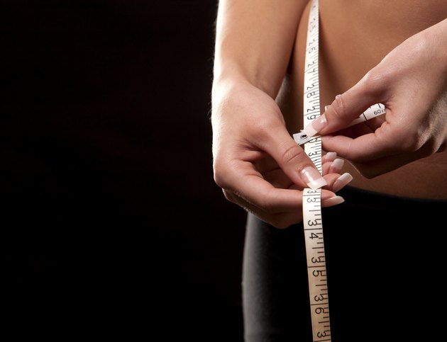 woman measuring her waist