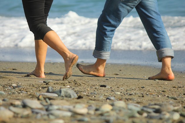 man and woman walking on the beach