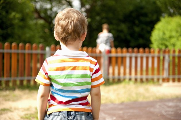 Young boy standing in playground, rear view