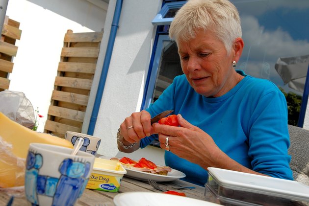 Elderly woman making lunch outdoors