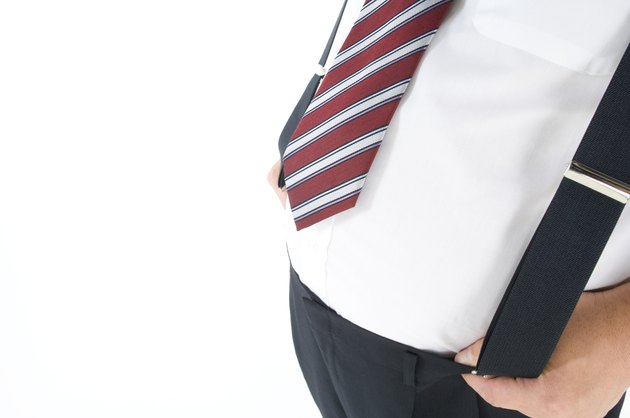 Overweight businessman with a pot belly holding his suspenders