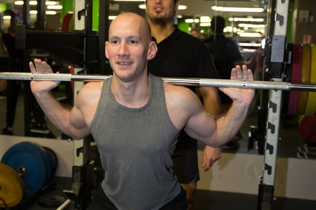 Gym personal trainer man with weight training equipment