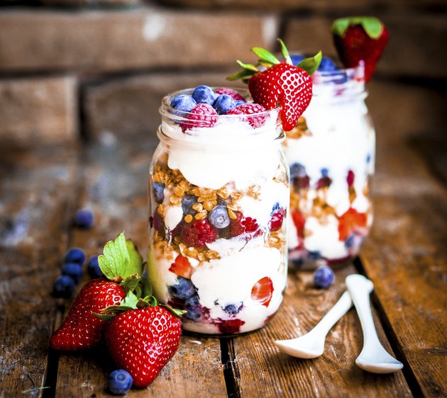 Granola Parfait with yogurt and berries on rustic background