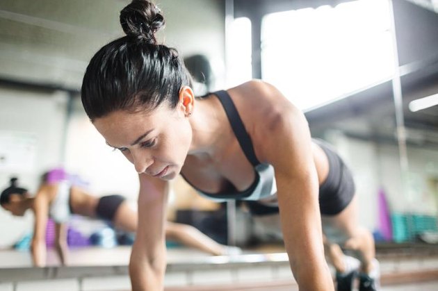 Young fit female doing push-ups in gym