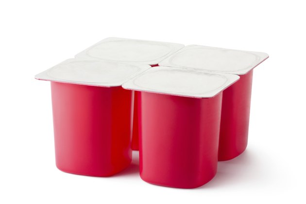 Four plastic containers for dairy products with foil lid