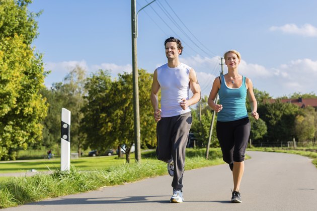 Sport couple running and jogging on rural street