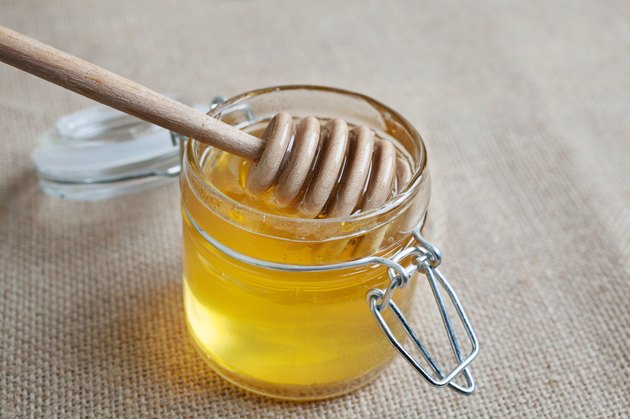 Honey jar isolated on jute background