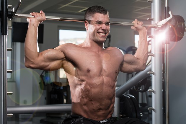 Male Bodybuilder Doing Heavy Weight Exercise For Shoulders