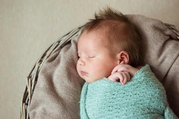 Newborn baby sleeps in a basket hairstyle Mohawk