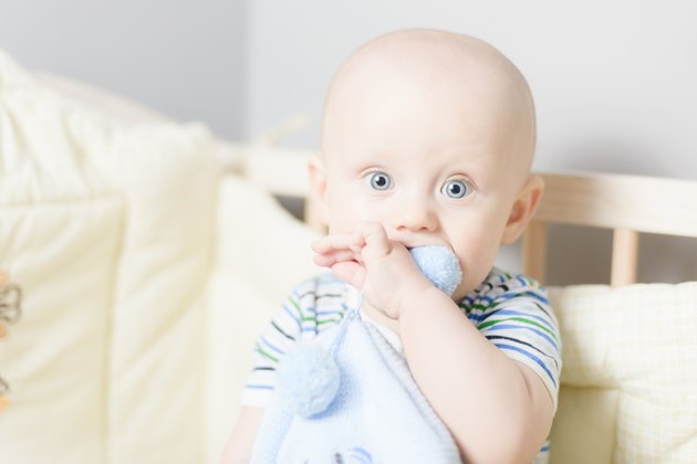 baby playing when sitting in crib