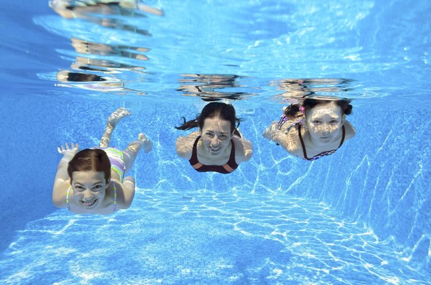 Happy family swim underwater in pool