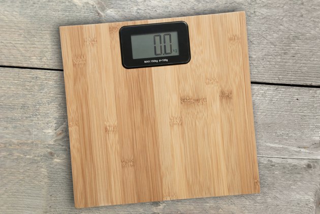 Electronic floor scale on a wooden background
