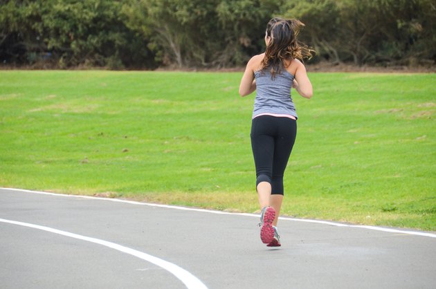 Athletic young woman running on track