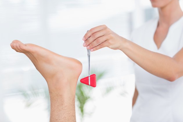 Physiotherapist using reflex hammer