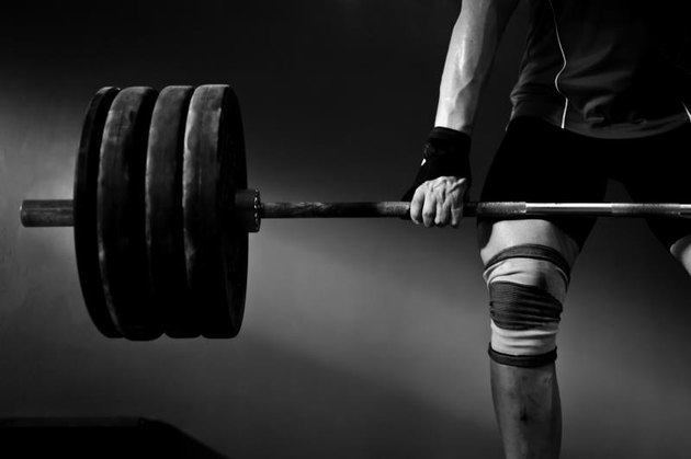 a photo of a man lifting barbell and disks