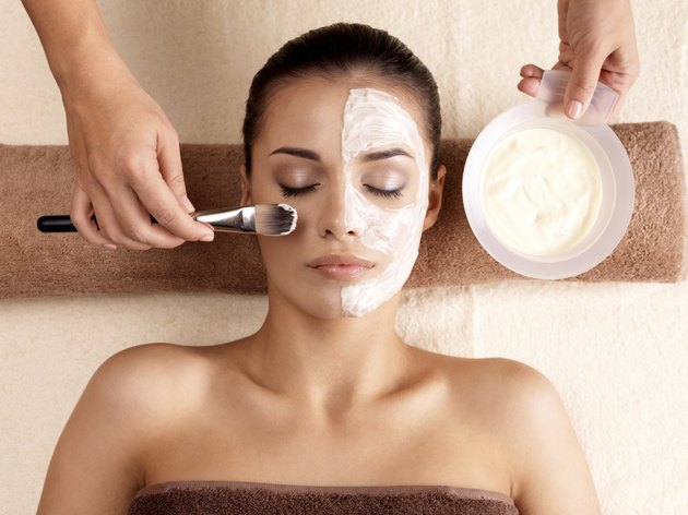 Spa therapy for woman receiving facial mask