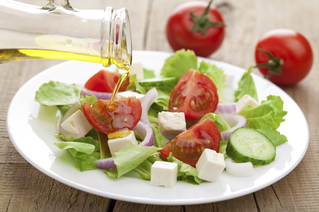 oil pouring over fresh salad
