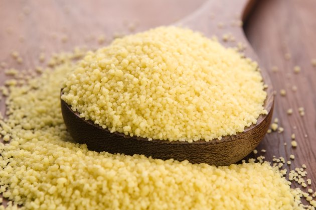 couscous in wooden spoon on kitchen table