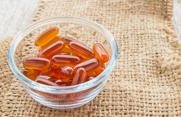Fish oil capsules in glass bowl on burlap sack