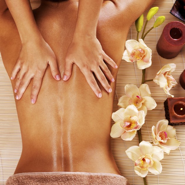Masseur doing massage on woman back in spa salon