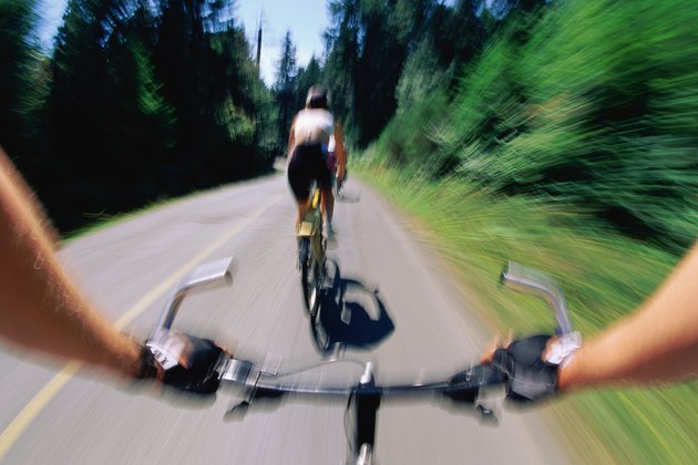 Two bike riders close-up view of hands and handlebar of one