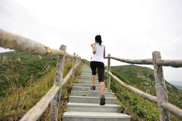 woman runner running at mountain stairs