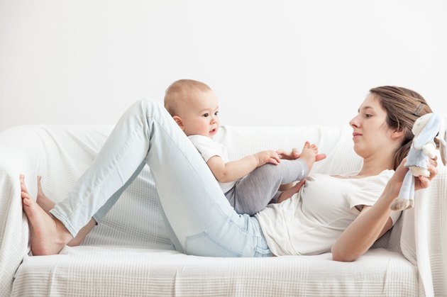 Mum playing with little child in the sofa