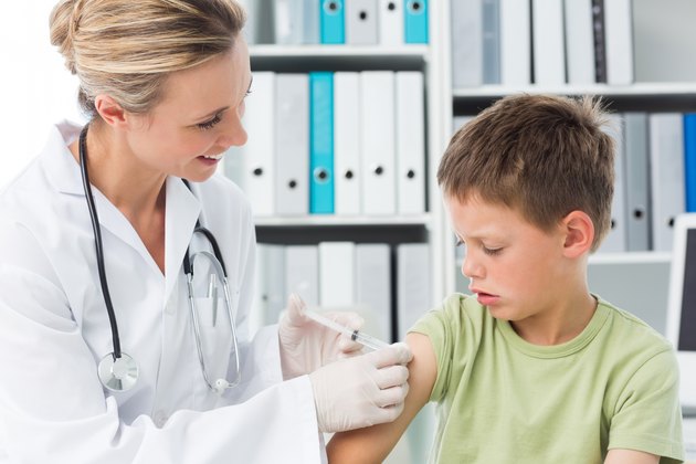 Boy receiving an injection by female doctor