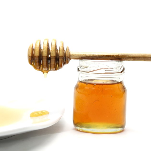 Honey and dipper on white background
