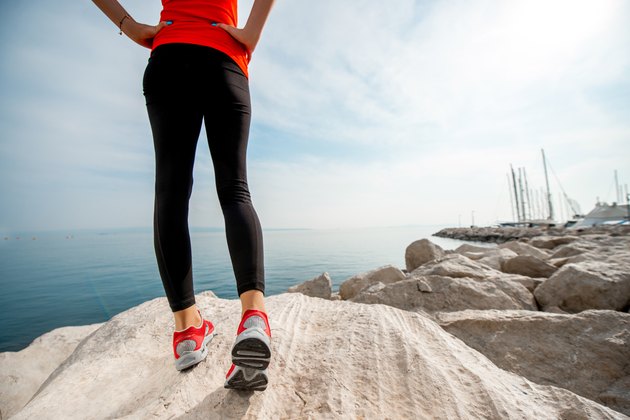 Sporty woman legs on the rocky beach