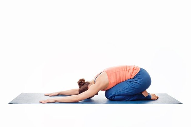 Woman doing Ashtanga Vinyasa Yoga relaxation asana Balasana - child posture - resting pose or counter asana for many asanas isolated on white background
