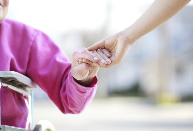 Senior Lady in Wheelchair Holding Hands