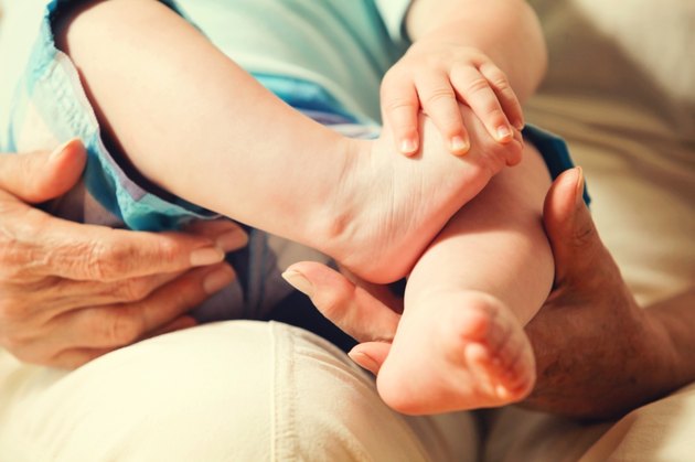 Grandmother's Hands Holding Newborn's Feet