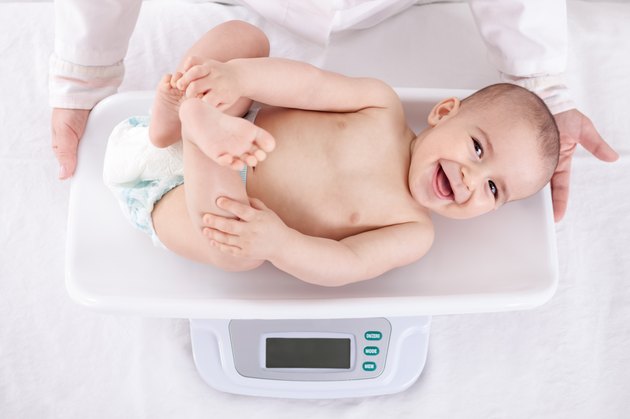 Measuring smiling beautiful comfortable little baby