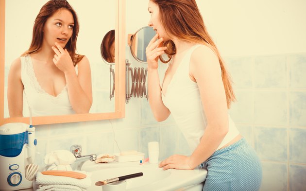 Woman without makeup in bathroom.