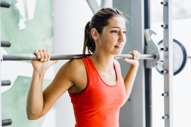 Young beautiful woman lifting weights in a gym