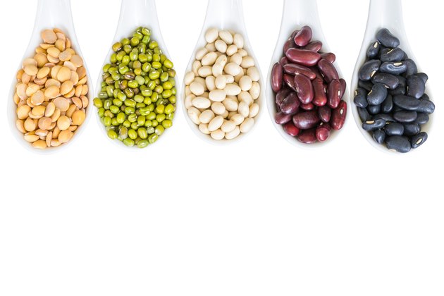 Different beans in white spoon