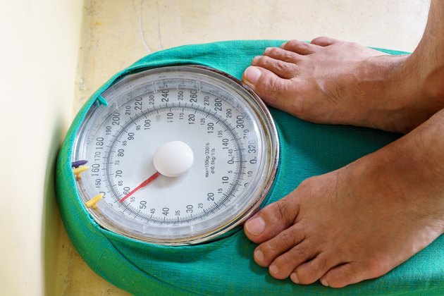 Man's feet standing on a weighing scale