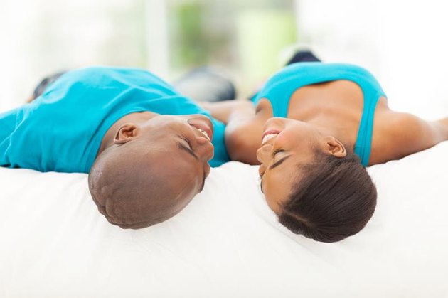 cute african couple lying on bed at home