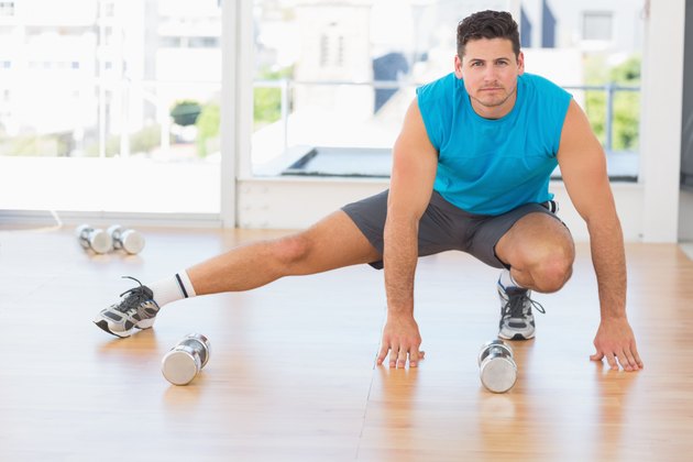 Full length portrait of a sporty man doing stretching exercise