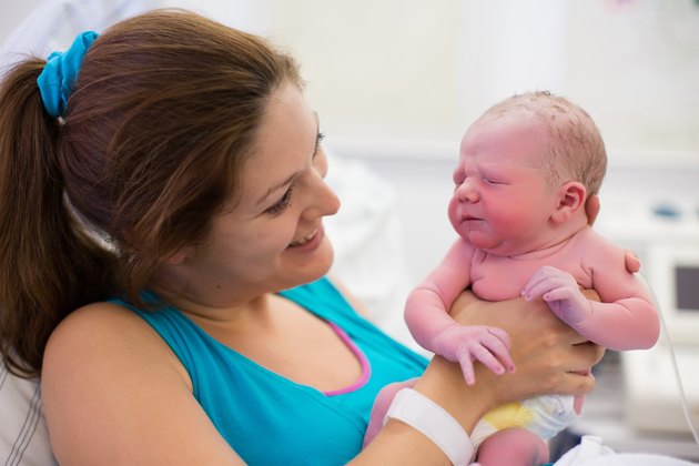Beautiful young mother giving birth to a baby