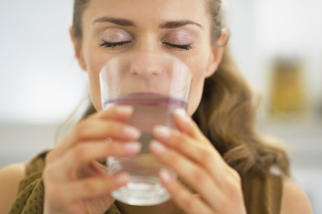 young housewife drinking water