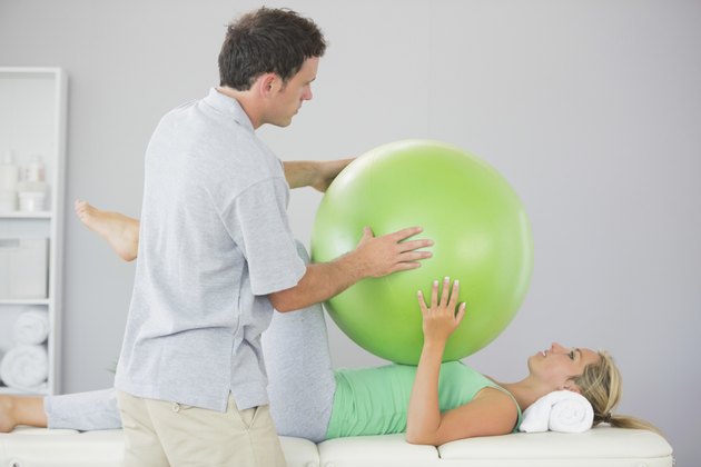 Patient training with exercise ball and physiotherapist