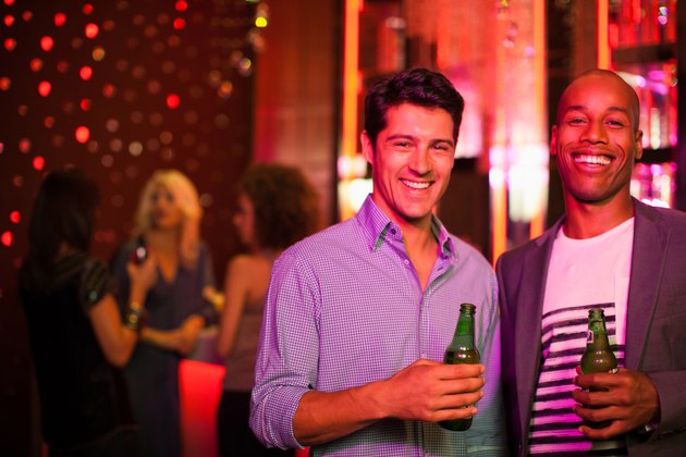 Men holding beer bottles in nightclub