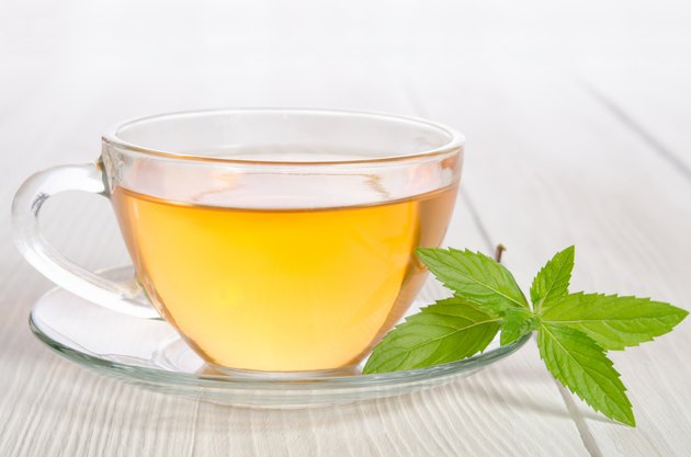 Glass cup of tea with mint on the wooden table