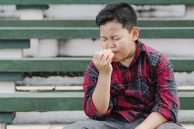 asian boy eating an apple