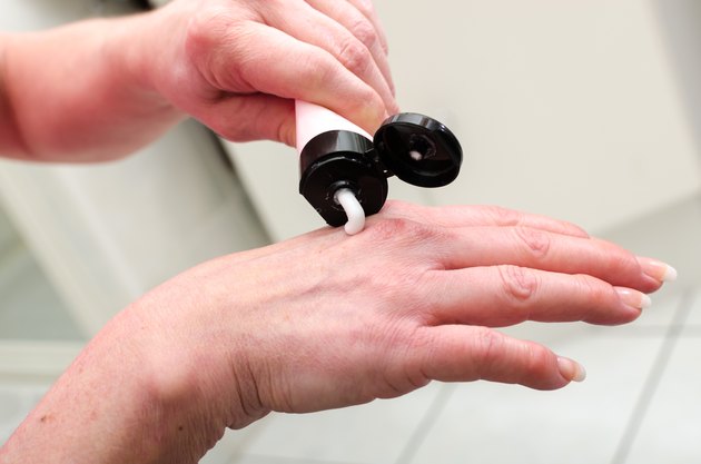 Woman putting cream on her hand